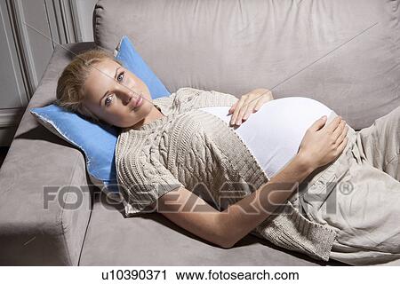 Pregnant woman relaxing on sofa View Large Photo Image Stock Image - Pregnant woman relaxing on sofa. Fotosearch