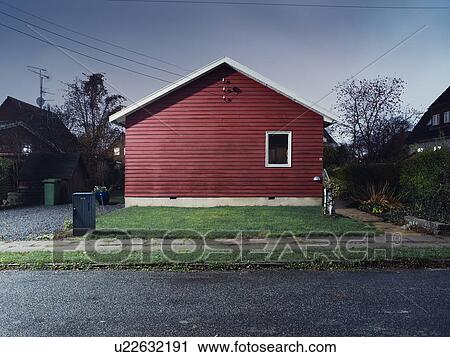 Stock Image - Red house on wet suburban street. Fotosearch