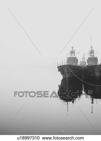 Stock Image - Ships docked in still harbor. Fotosearch