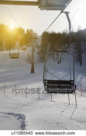 Stock Image - Ski chairlift over snowy landscape. Fotosearch