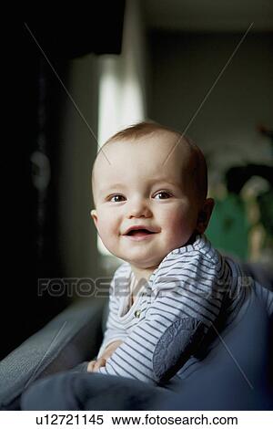 Stock Photography - Smiling baby crawling on sofa. Fotosearch