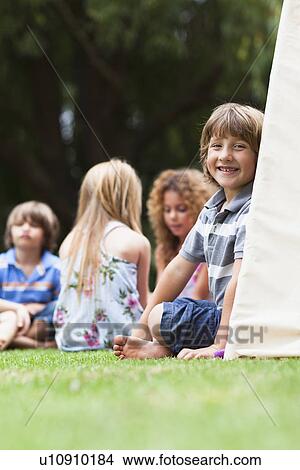 Smiling boy sitting in tent outdoors View Large Photo Image Picture - Smiling boy sitting in tent outdoors. Fotosearch