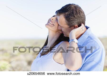 Smiling couple hugging outdoors View Large Photo Image Stock Photograph - Smiling couple hugging outdoors. Fotosearch
