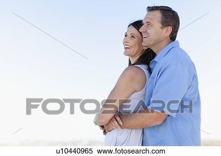 Smiling couple hugging outdoors View Large Photo Image Stock Photography - Smiling couple hugging outdoors. Fotosearch