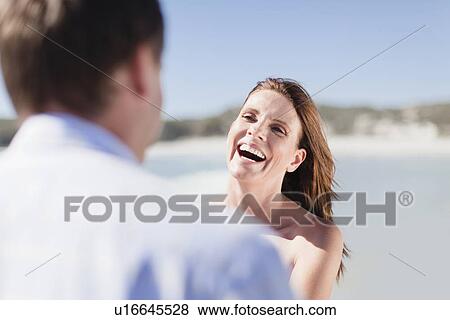 Stock Photo - Smiling couple walking on beach. Fotosearch