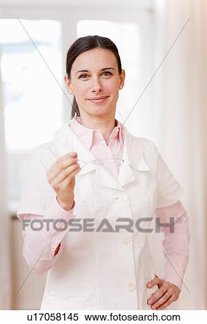 Smiling doctor holding glasses View Large Photo Image Stock Photography - Smiling doctor holding glasses. Fotosearch