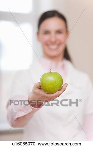 Smiling doctor offering green apple View Large Photo Image Stock Image - Smiling doctor offering green apple. Fotosearch