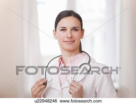 Stock Photograph - Smiling doctor wearing stethoscope. Fotosearch