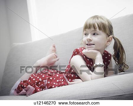 Smiling girl relaxing on sofa View Large Photo Image Stock Image - Smiling girl relaxing on sofa. Fotosearch