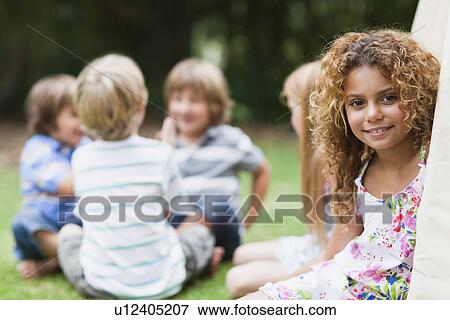 Stock Photo - Smiling girl sitting in tent outdoors. Fotosearch