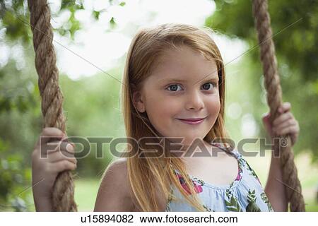 Smiling girl sitting in tree swing View Large Photo Image Stock Image - Smiling girl sitting in tree swing. Fotosearch