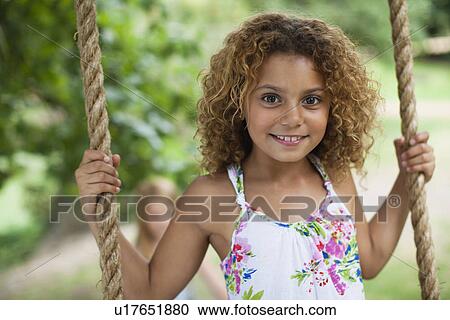 Smiling girl standing on tree swing View Large Photo Image Stock Image - Smiling girl standing on tree swing. Fotosearch