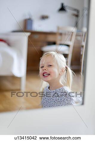 Stock Image - Smiling girl walking in bedroom. Fotosearch
