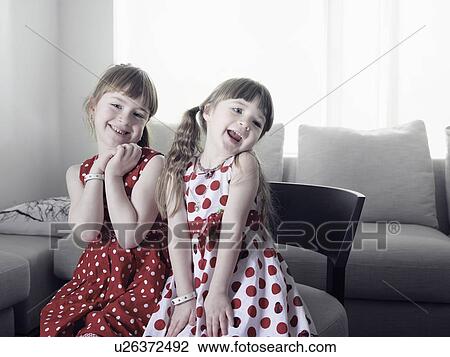 Smiling girls sitting in chair View Large Photo Image Stock Image - Smiling girls sitting in chair. Fotosearch
