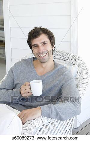 Smiling man having cup of coffee View Large Photo Image Stock Image - Smiling man having cup of coffee. Fotosearch
