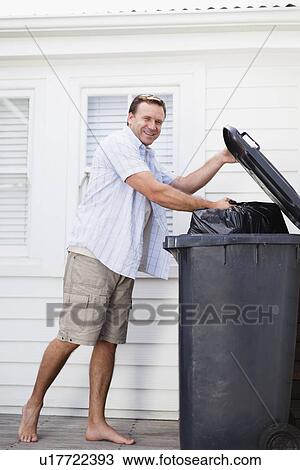Smiling man taking out garbage View Large Photo Image Stock Image - Smiling man taking out garbage. Fotosearch
