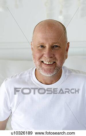 Smiling older man sitting on sofa View Large Photo Image Stock Photo - Smiling older man sitting on sofa. Fotosearch