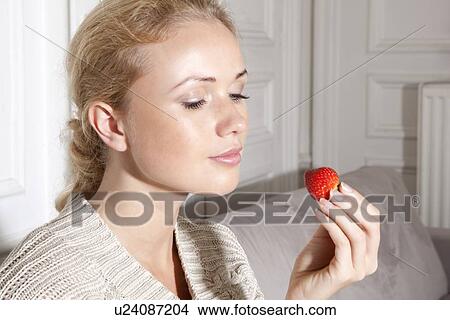 Smiling woman eating strawberry View Large Photo Image Picture - Smiling woman eating strawberry. Fotosearch