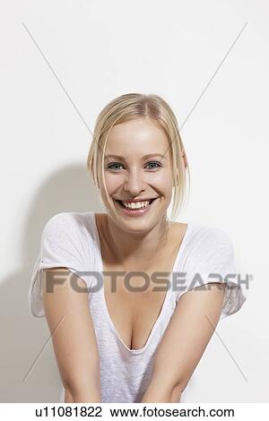Smiling woman leaning against wall View Large Photo Image Stock Image - Smiling woman leaning against wall. Fotosearch