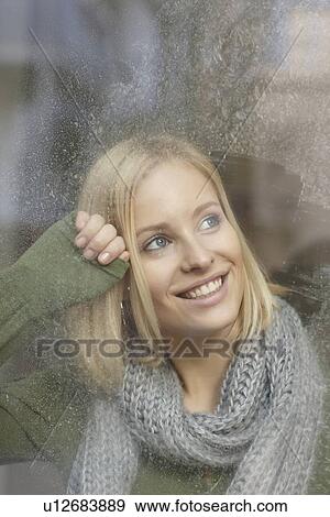 Smiling woman standing at frosty window View Large Photo Image Stock Photo - Smiling woman standing at frosty window. Fotosearch