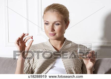 Smiling woman taking medication View Large Photo Image Stock Photo - Smiling woman taking medication. Fotosearch