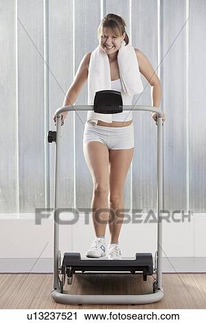 Smiling woman using exercise machine View Large Photo Image Stock Image - Smiling woman using exercise machine. Fotosearch
