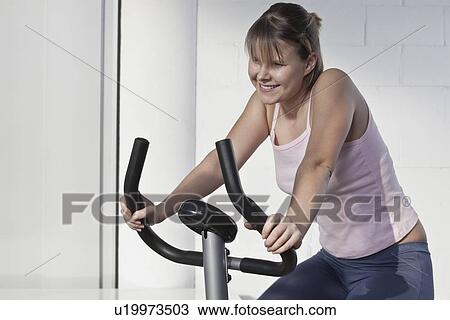 Smiling woman using exercise machine View Large Photo Image Stock Image - Smiling woman using exercise machine. Fotosearch