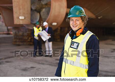 Smiling worker standing on dry dock View Large Photo Image Stock Image - Smiling worker standing on dry dock. Fotosearch
