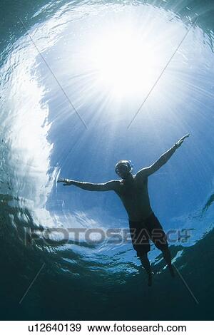 Snorkeler swimming in tropical water View Large Photo Image Stock Photo - Snorkeler swimming in tropical water. Fotosearch