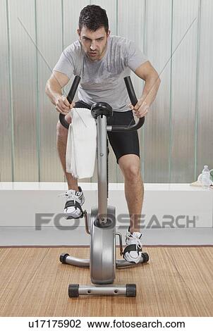 Struggling man using exercise machine View Large Photo Image Stock Image - Struggling man using exercise machine. Fotosearch
