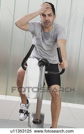 Struggling man using exercise machine View Large Photo Image Stock Photography - Struggling man using exercise machine. Fotosearch
