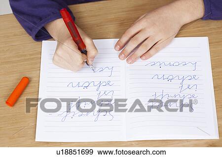 Stock Photo - Student practicing handwriting in class. Fotosearch