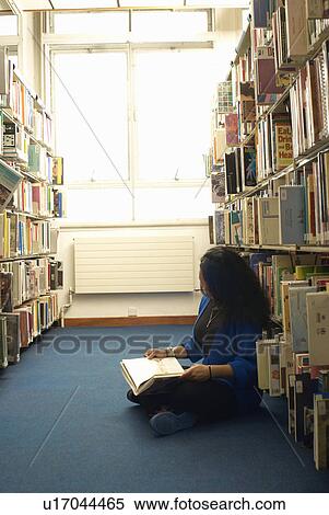 Stock Photography - Student reading in library. Fotosearch