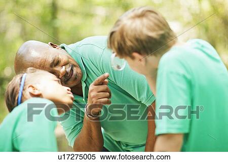 Stock Photography - Students examining plants with teacher. Fotosearch