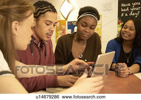Students working together at desk View Large Photo Image Stock Photograph - Students working together at desk. Fotosearch