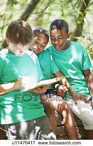 Stock Photo - Students writing notes outdoors. Fotosearch