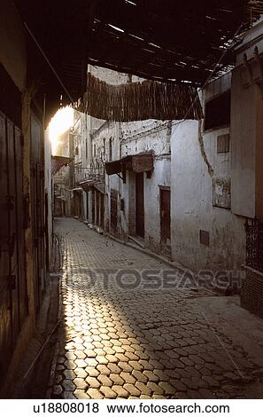 Sun rising over village alleyway View Large Photo Image Stock Photo - Sun rising over village alleyway. Fotosearch