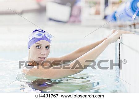 Stock Photo - Swimmer climbing out of pool. Fotosearch