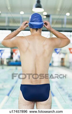 Swimmer putting on goggles by pool View Large Photo Image Stock Photograph - Swimmer putting on goggles by pool. Fotosearch
