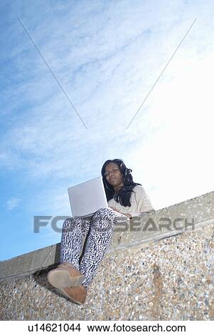 Teenager using laptop outdoors View Large Photo Image Picture - Teenager using laptop outdoors. Fotosearch