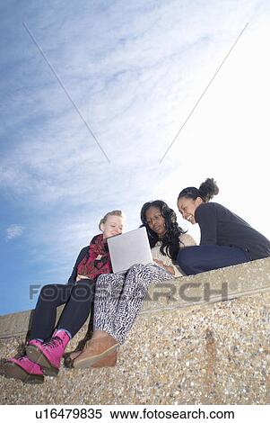 Teenagers using laptop outdoors View Large Photo Image Stock Photography - Teenagers using laptop outdoors. Fotosearch