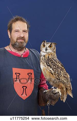 Picture - Trainer holding owl on arm. Fotosearch