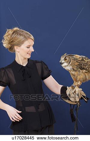 Stock Photography - Trainer holding owl on arm. Fotosearch