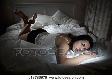 Upset woman lounging in bed View Large Photo Image Stock Photo - Upset woman lounging in bed. Fotosearch