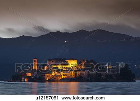 Stock Image - Village on island lit up at night. Fotosearch