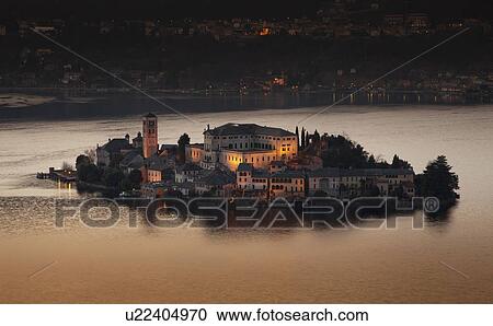Stock Image - Village on island lit up at night. Fotosearch