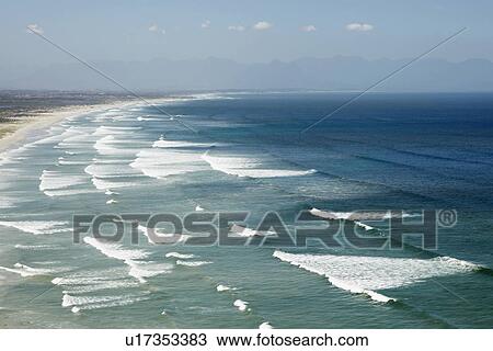 Stock Image - Waves rolling on sandy beach. Fotosearch