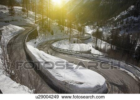 Winding road in snowy landscape View Large Photo Image Stock Photo - Winding road in snowy landscape. Fotosearch