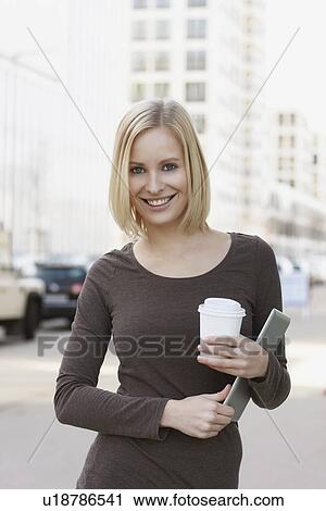 Stock Image - Woman carrying tablet computer. Fotosearch