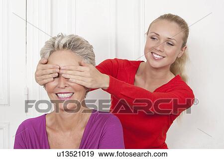 Woman covering mothers eyes View Large Photo Image Stock Photo - Woman covering mothers eyes. Fotosearch